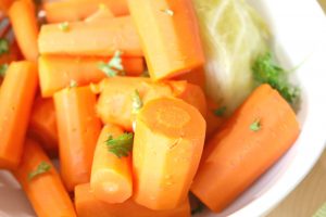 close up of cooked carrots and cabbage with parsley on top