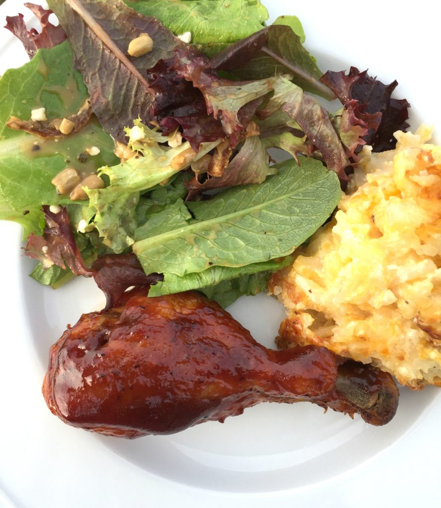 dinner plate with chicken drumstick, salad, and potatoes