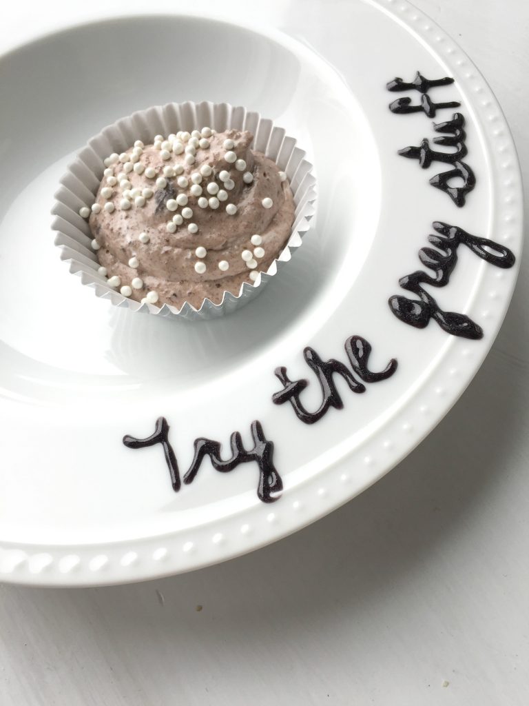 "Try the grey stuff" written on a plate that's holding the grey stuff dessert