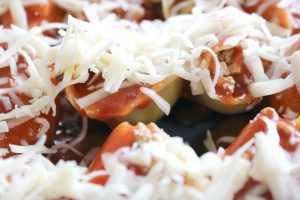 taco stuffed shells - covered in shredded cheese